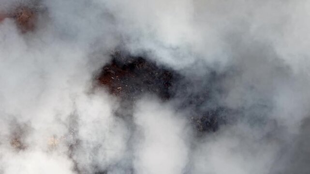 Aerial drone view of fire burning at landfill site