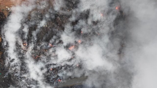 Aerial drone view of landfill fire burning at waste site