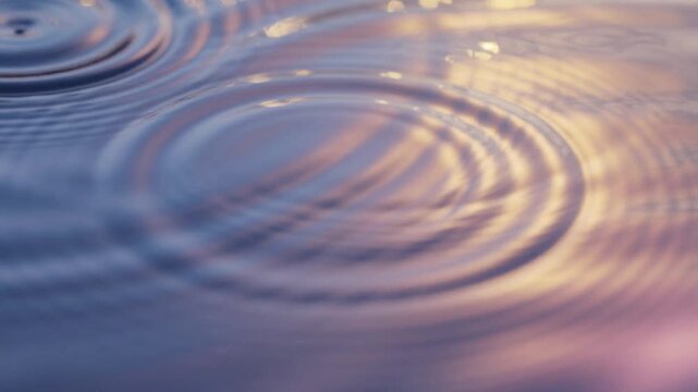 Close up of water ripples with soft sunset reflections creating peaceful and calming natural scene