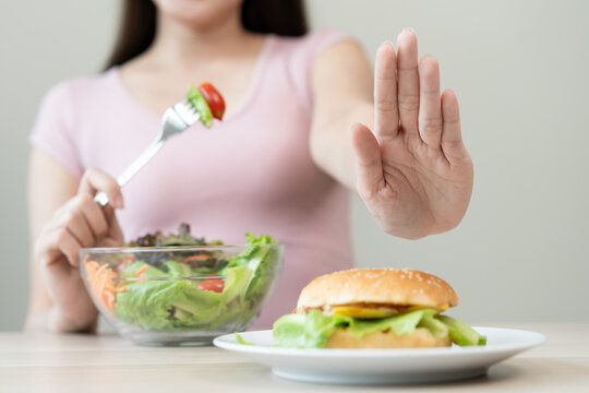 A person who avoids eating high-calorie junk food in high calories to control cholesterol and sugar during a diet session for weight loss and good health