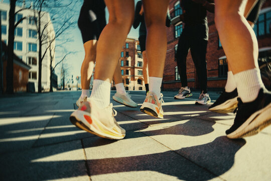 Running shoes in motion during urban city warm up on pavement