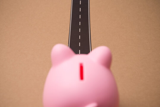 Piggy bank walks alone on the road. Focus on financial planning and management for achieve savings target, financial freedom, personal wealth, pension retirement, money literacy and discipline concept