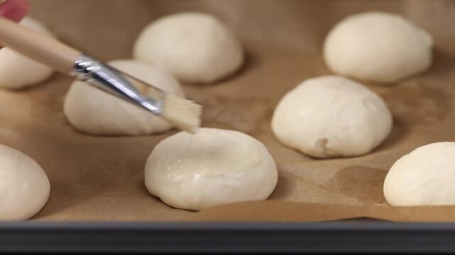 Grease raw buns before baking with egg mixture