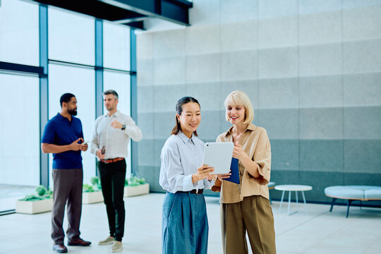 Diverse business professionals collaborating and communicating in a modern office, sharing ideas and making decisions using technology