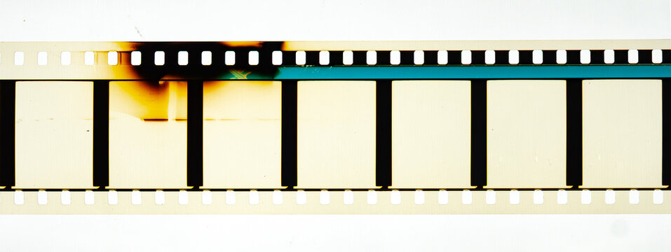 Long horizontal vintage 35mm motion picture film strip featuring blank frames and classic sprocket holes. Authentic analog cinema celluloid isolated on white with dark burn marks and light leaks