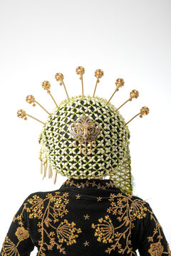 Detailed close-up of a traditional Javanese bridal jasmine flower headpiece (ronce melati) with golden hairpins on a black velvet kebaya.