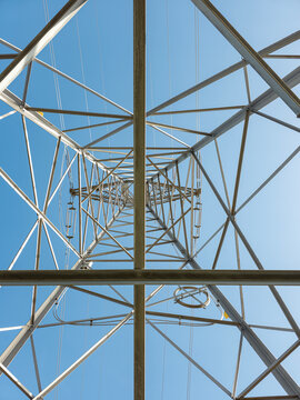 Steel lattice structure of high voltage electricity transmission tower against clear blue sky