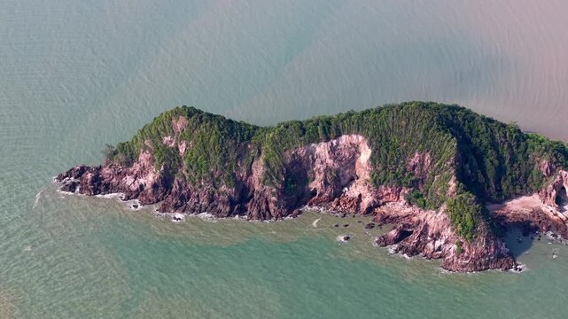 Aerial view shows a rugged, green island surrounded by calm waters