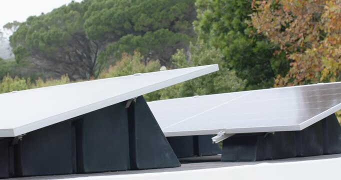 Camera is panning left upward to reveal fixed solar panels on roof, showing mounts and canopy