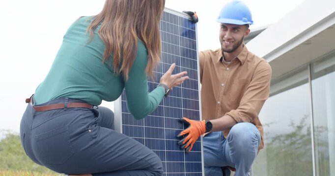 African American team starting setup, kneeling and raising solar panel on deck with gloves for sun