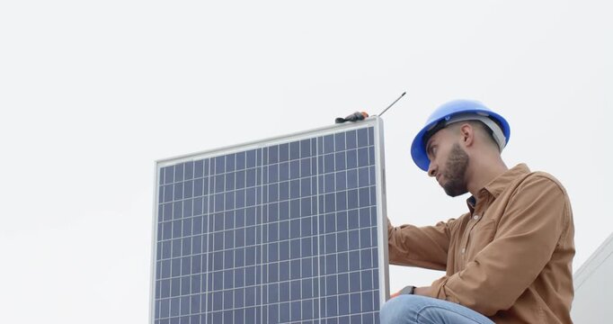 African American man kneeling on roof panel seeing tool donning gloves aligning mount, copy space