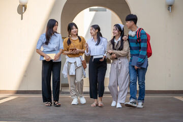 Fototapeta premium A diverse group of students strolls across campus sharing conversations and enjoying their time together
