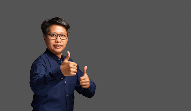 Mature woman giving thumbs up in studio portrait