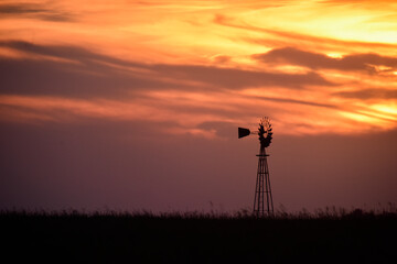 Fototapeta premium Windmill in the Argentine Countryside, at sunset, La Pampa Province, Patagonia, Argentina.