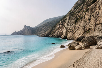 Obraz premium A scenic view of a sandy beach meeting turquoise water, backed by rugged, arid cliffs under a bright sky.