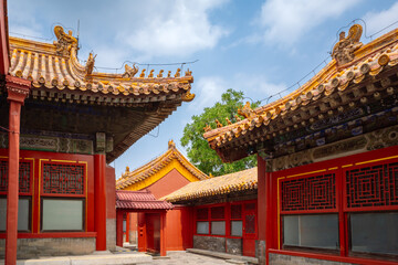 Fototapeta premium Traditional Imperial Palace Architecture with Yellow Tiled Roofs and Imperial Roof Decorations at Daytime in the Forbidden City, Beijing, China