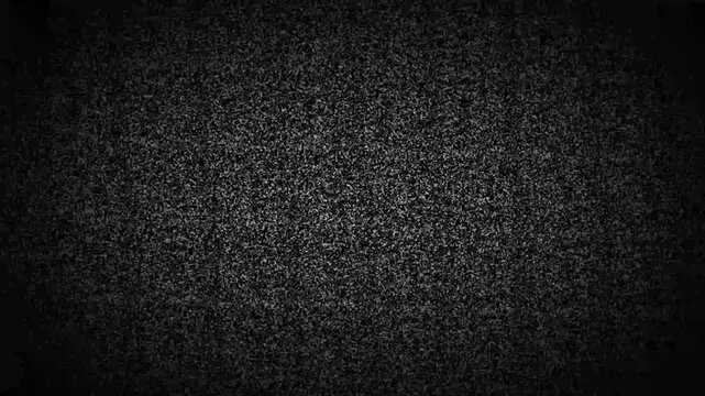 Static television noise texture with grainy black and white dots creating a flickering analog screen effect on a dark background with subtle vignetting