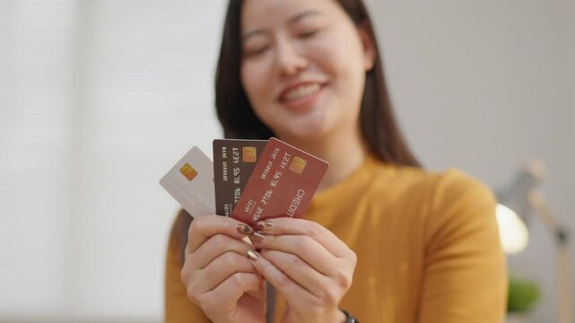 Happy woman holding credit cards, ideal for personal finance, banking, card benefits, consumer spending, shopping and payment concept.
