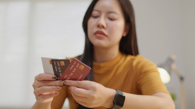 Woman stressed while holding multiple credit cards, ideal for debt, overspending, budgeting, money anxiety, financial pressure and personal finance problem concepts.