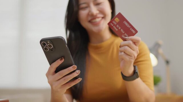 Happy woman using a credit card and smartphone to enjoy rewards, ideal for cashback, loyalty programs, online shopping, digital payment and personal finance concepts.