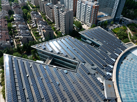 Aerial view of photovoltaic panel arrays installed on urban building rooftops in Shouguang