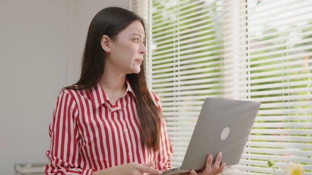 Stressed woman working on a laptop with hands on her head, ideal for deadline pressure, burnout, work overload, office anxiety, mental stress and productivity problems.