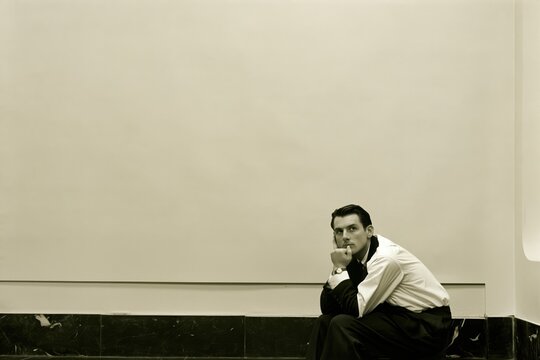 Accountant sitting and thinking in front of a blank wall in 1998