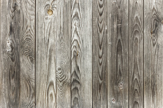 Weathered gray wooden planks create a rustic textured background with visible grain, knots and weathering, perfect for product mockups, website headers, interior design concepts, vintage projects