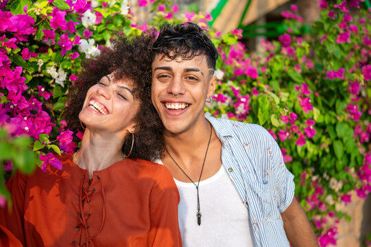 A multicultural couple enjoys a moment of love and connection in a beautiful blooming summer garden