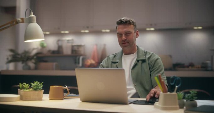 360 Degree. Caucasian Man Typing on Laptop Computer at Cozy Home Desk, Managing Online Calendar, Taking Notes and Organizing Schedule While Focused on Remote Work in Modern Apartment. Tracking Shot