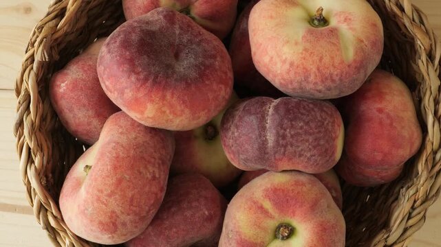 Basket of fresh ripe flat peaches