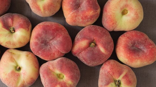 Ripe organic flat peaches moving slowly
