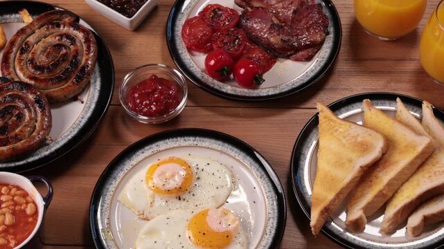 Full English Breakfast Platter with Spiral Sausages, Beans, Eggs, Tomatoes, Bacon and Toast 