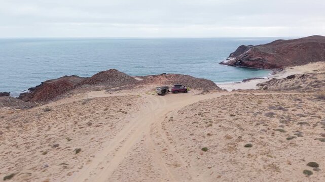 A cliffside camping trip in Baja California with an SUV and a teardrop trailer by the Pacific Ocean. Enjoying the view and adventure.