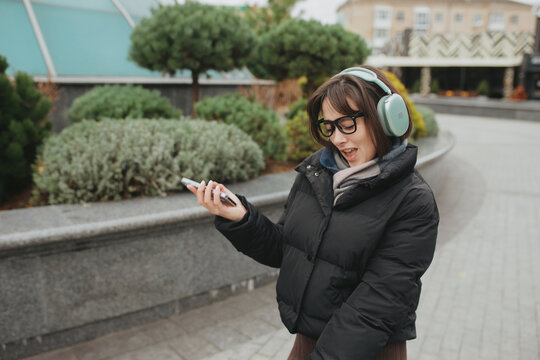 Woman listening to music with headphones outdoors in city park
