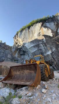 Old abandoned excavator inside a majestic rusty marble stone quarry