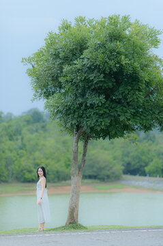 Beautiful Woman in White Outfit Standing by Tree in Khao Yai Thailand