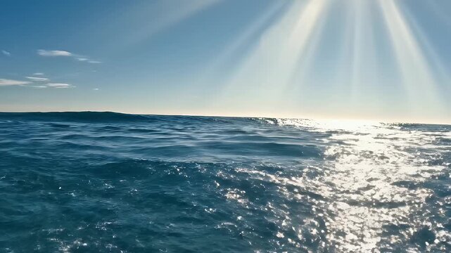 Sunlight streams through the sky, illuminating a powerful ocean wave breaking.