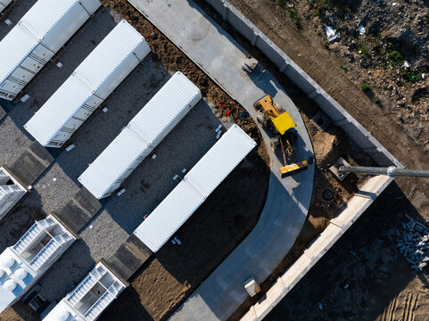 Construction site of containerized energy storage power station with heavy machinery and modular units