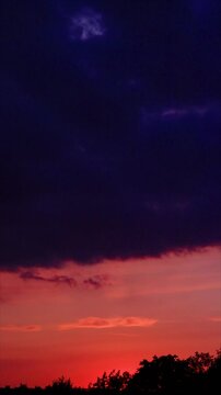 Dramatic sunset sky timelapse with fast moving clouds, colorful evening horizon with vibrant red and orange tones, scenic nature background, atmospheric twilight sky, dynamic cloudscape at dusk