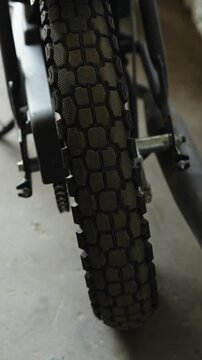 Close-up of a knobby dual-sport motorcycle tire with a blocky tread pattern 