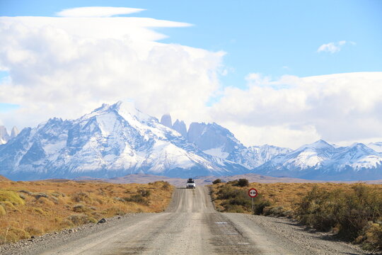 Carro em estrada na Patag&ocirc;nia chilena com as Torres del Paine ao fundo