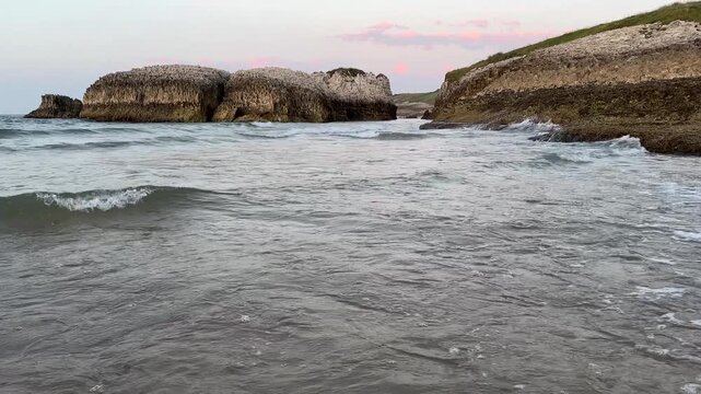 Gentle ocean waves beneath a soft evening sky with soothing sounds of splashing water.