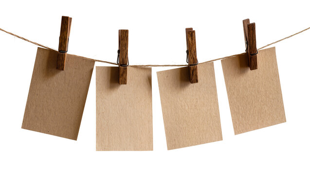 Four blank brown paper cards held by wooden clothespins on twine, isolated on transparent background