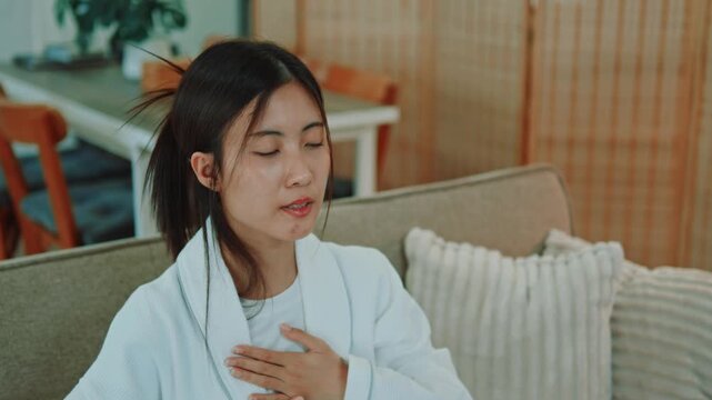 An Asian woman relaxing as she wakes up early for mental healing, taking a deep breath to relax into her daily life