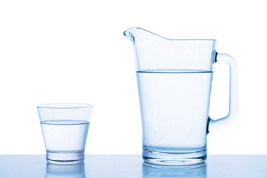 decanter and glass with drinking water on table isolated on white background