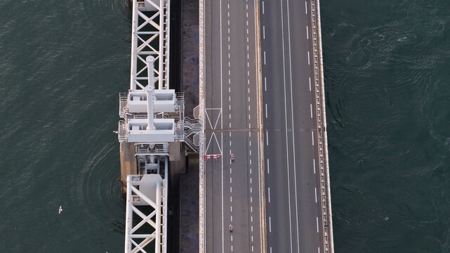 Aerial view of the Peilerdam section of the Oosterscheldekering storm surge barrier with a road bridge spanning the water in Burgh-Haamstede, Zeeland, Netherlands.