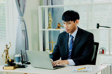 Naklejka premium Professional lawyer consulting a client and verifying lawsuit data on laptop for legal accuracy.