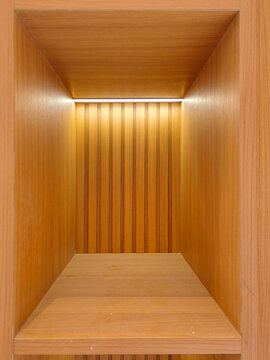 Jakarta, Indonesia - June 24, 2026: Interior wall niche area of a residential house with a light brown oak wood pattern HPL finishing layer equipped with a warm white LED strip light.