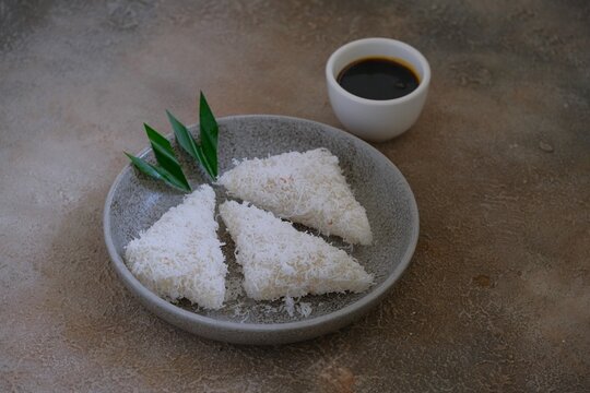 Traditional Indonesian Lupis or Lopis Cake with Shredded Coconut and Palm Sugar Syrup. Made from Steamed Coconut Rice.
